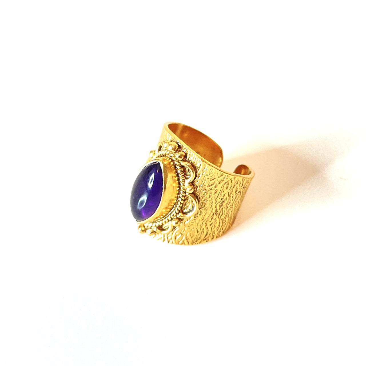 Espectacular anillo de bronce con baño de oro. El detalle central es de Amatista. Este anillo es ajustable lo que lo hace perfecto. Además es super combinable con tu look favorito. Lateral